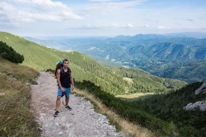 junger Mann mit Rucksack auf einem Bergpfad